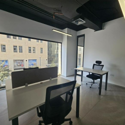 Office suite with a grey desk partition and city views.
