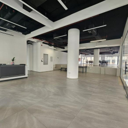 Bright reception area with a minimalist front desk and white pillars.