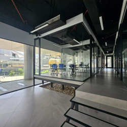 Elevated glass-enclosed meeting room overlooking the city boulevard.