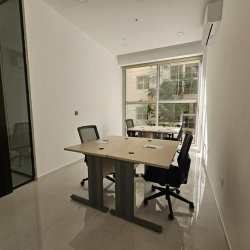 Bright office space with two desks and large window.