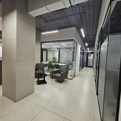 Hallway with seating area featuring two chairs and a small table.