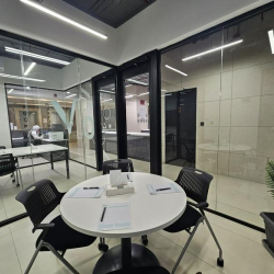 Cozy meeting area with a round table and two chairs surrounded by glass walls.