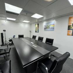 Executive conference room with a sleek dark table, leather chairs, and abstract wall art.