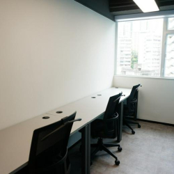 Two-person private office with a large window and white desks.