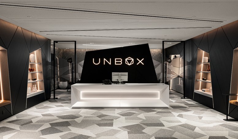 Futuristic white reception desk at unbox featuring a black angular backdrop.