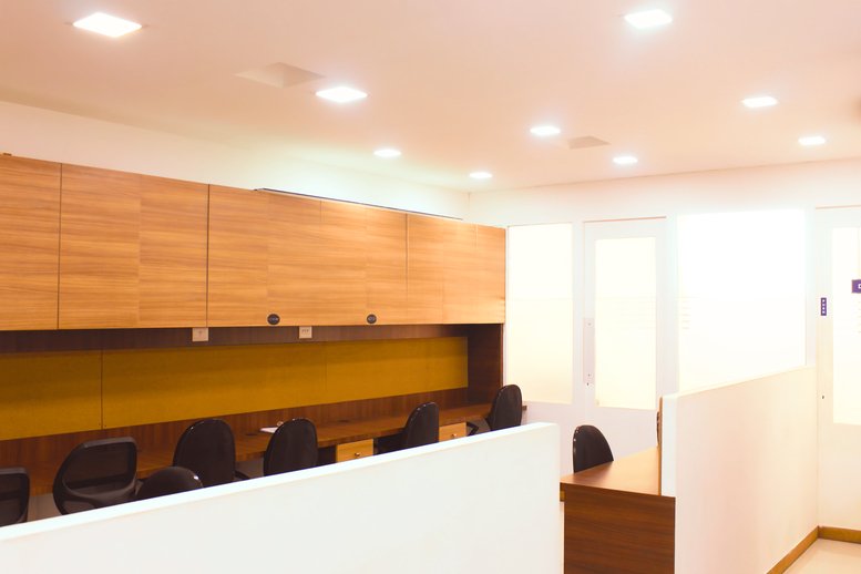 Open-plan workspace with wooden cabinetry and yellow backsplash at Vascon Platinum Square.