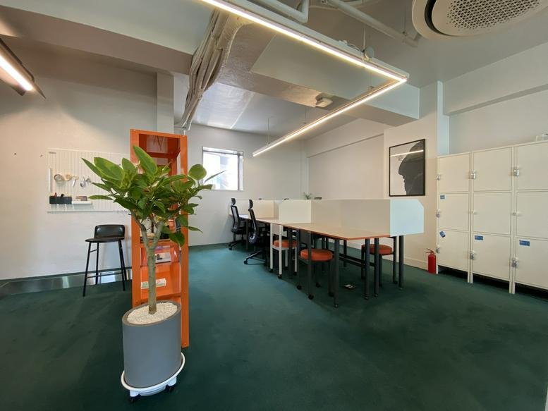 Spacious open-plan coworking area at 80-2, Jongno, Jongno-gu, Seoul with green carpet and a tall potted plant.