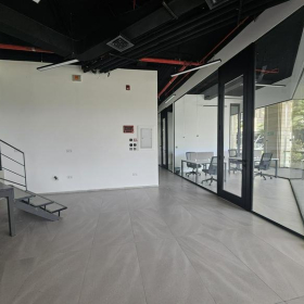 Modern interior workspace at V Business Center Abdali Boulevard, Amman featuring glass walls and industrial ceilings.. Click for details.