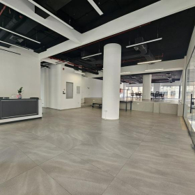 Bright reception area with a minimalist front desk and white pillars.. Click for details.